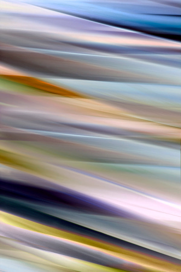 Abstract blurred streaks of light in diagonal bands of blue, gray, beige, yellow, and purple.